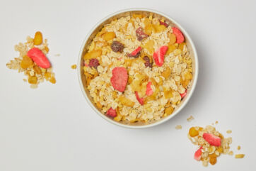 Molino Nicoli-Bowl of protein muesli with red fruits. Healthy breakfast cereal with oats, strawberries, and dried fruit.