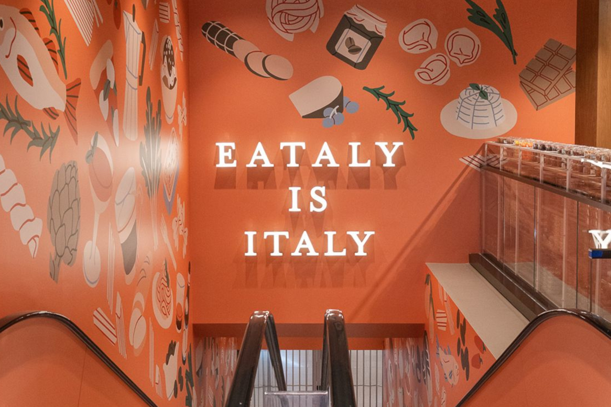 Eataly Toronto store entrance. Italian food market with Eataly is Italy sign, escalator, and food illustrations.