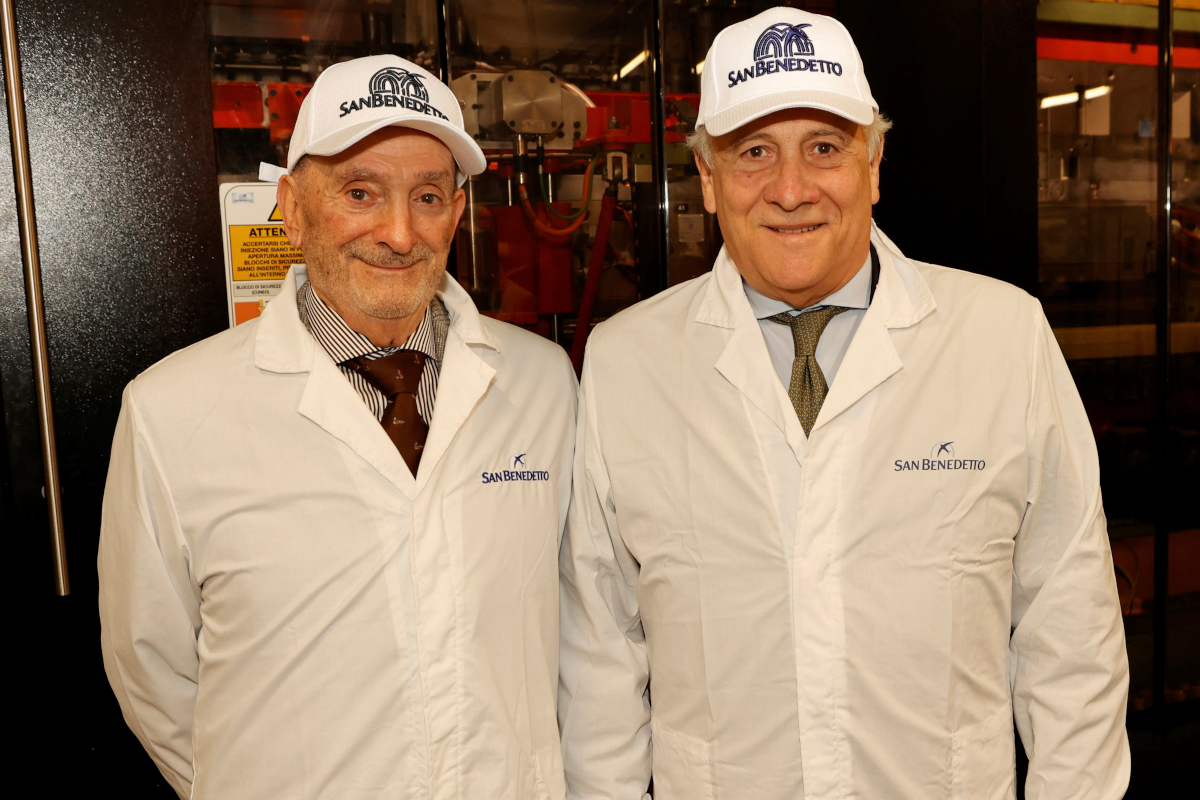 Enrico Zoppas and Ministro Tajani at San Benedetto plant. Two men in lab coats and San Benedetto caps.