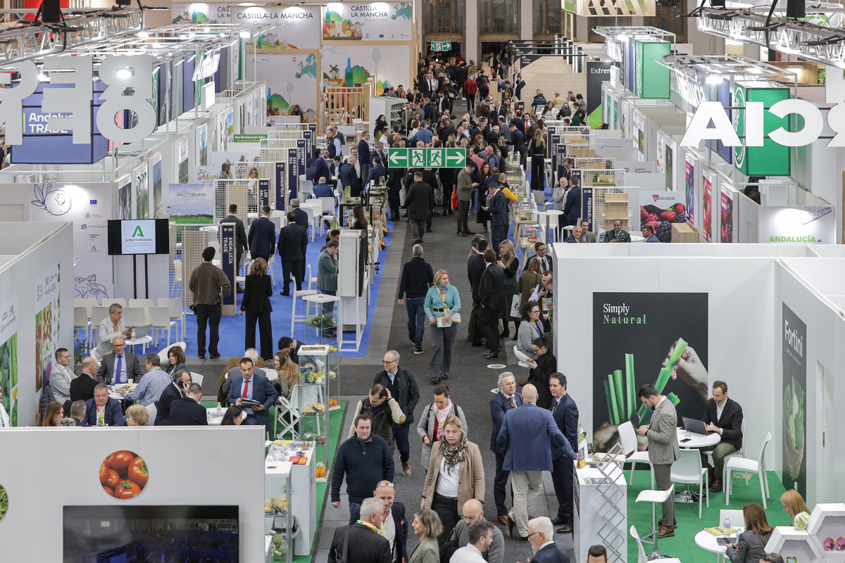 Fruit Logistica trade show floor with crowds of people at vendor booths.