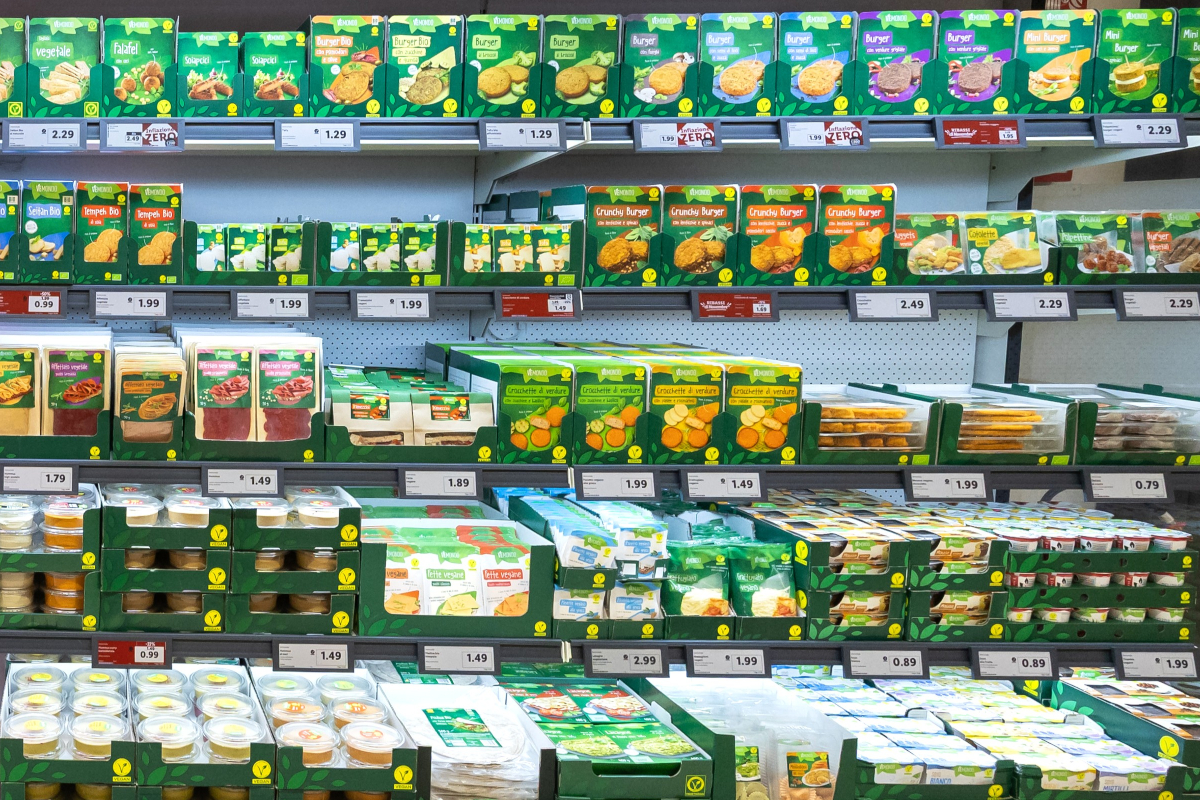 Lidl Vemondo vegan product selection on grocery store shelves in Italy. Plant-based burgers, dips, and snacks.
