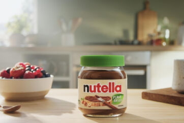 Plant-based Nutella jar on a wooden table. Vegan hazelnut spread with berries.