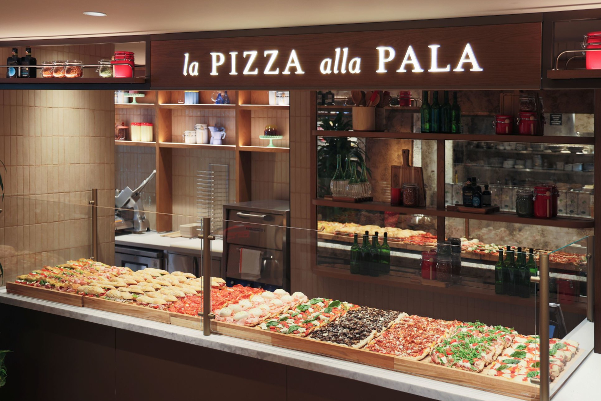 Eataly West Palm Beach's La Pizza alla Pala counter. Fresh Italian pizza on display. Restaurant interior.