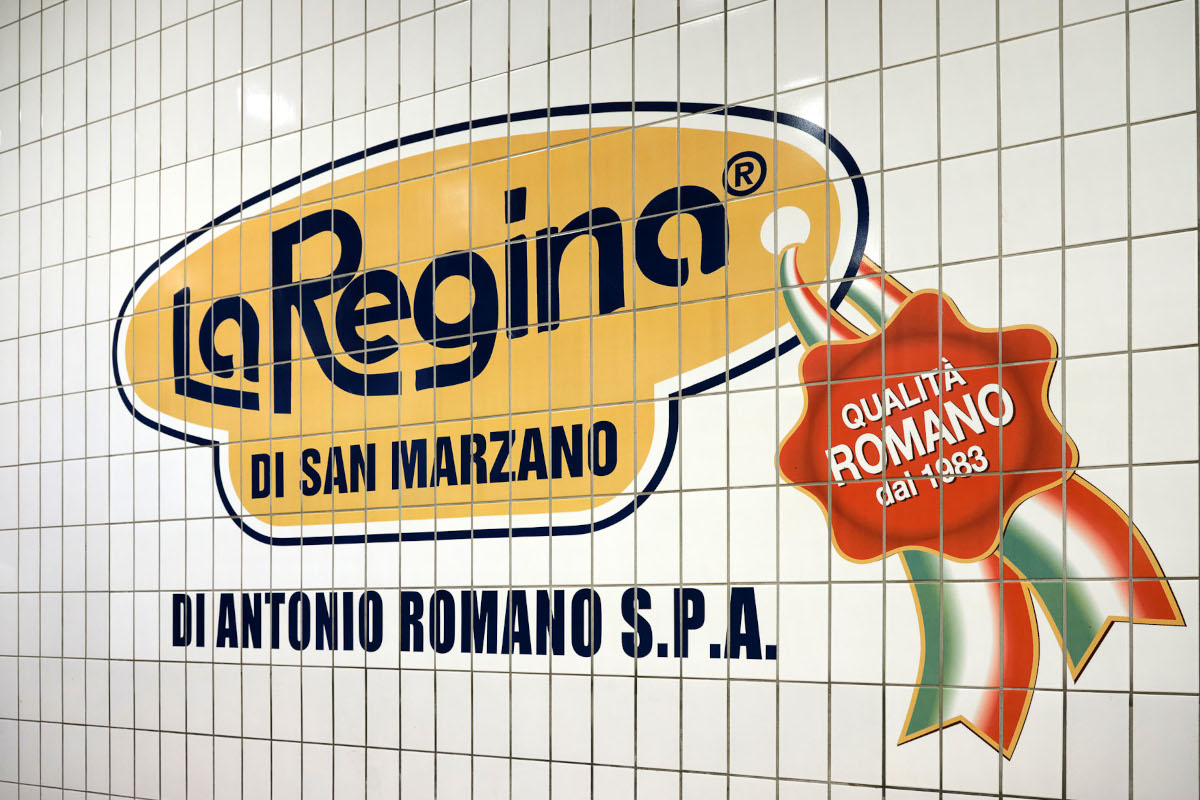 Logo La Regina di San Marzano sulla parete piastrellata. Marchio di pomodori italiani. Acquisizione del marchio Campbell.