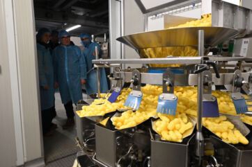 Corn puffs snack food production line at Molino Nicoli factory. Food manufacturing.
