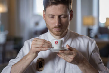 Chef Johannes Nuding, illycaffè's new ambassador, holds an illy espresso cup. Michelin-star chef enjoying coffee.