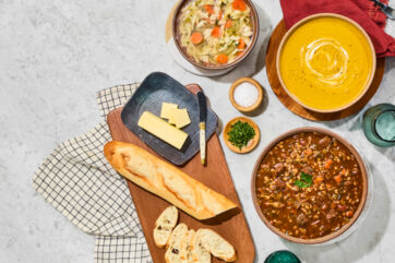 Whole Foods 2026 Trends: Soups, bread, and butter on a marble surface. Healthy grocery trends.