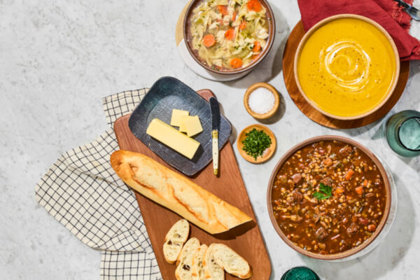 Whole Foods 2026 Trends: Soups, bread, and butter on a marble surface. Healthy grocery trends.