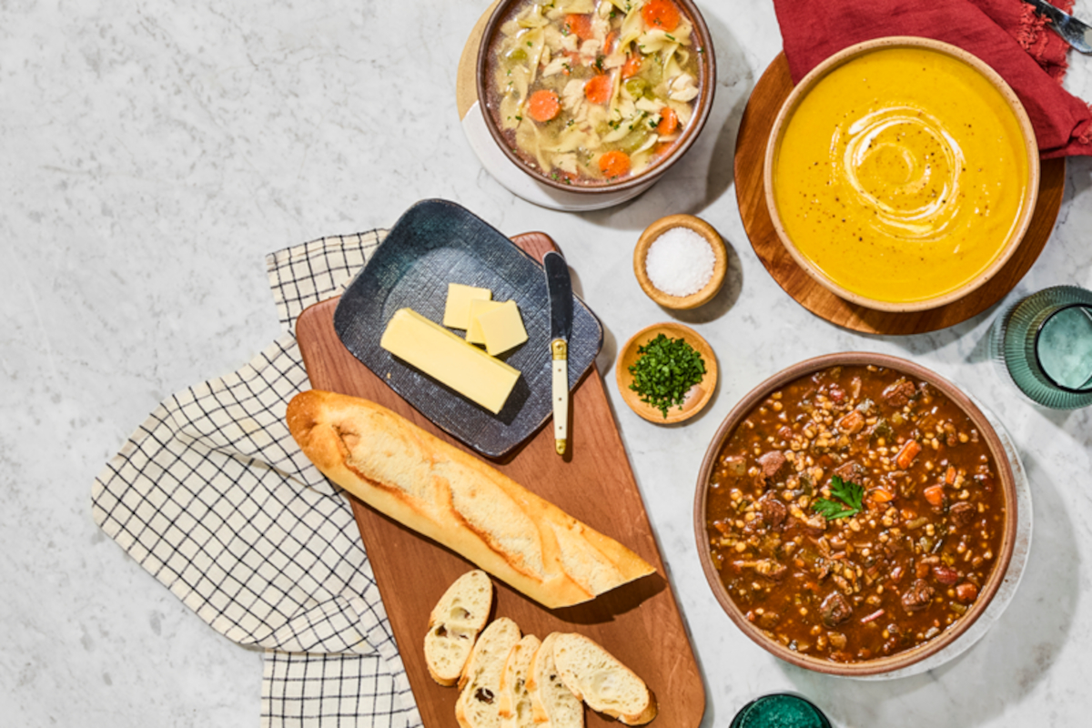 Whole Foods 2026 Trends: Soups, bread, and butter on a marble surface. Healthy grocery trends.