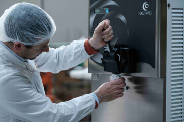 Gelato production: Worker making Italian ice cream with a Gelmatic machine. Fresh dessert.