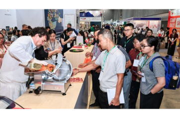 Chef slicing Italian cured meats for tasting at Food & Hospitality Vietnam. Assica showcases excellence in salumi.