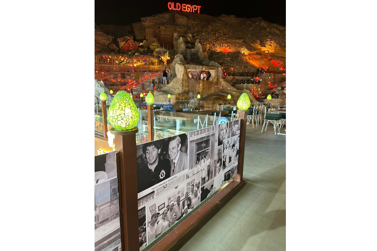 Antica Pizzeria Da Michele in Sharm el-Sheikh, Egypt. Outdoor dining with Old Egypt sign, stone waterfall, and photo collage.