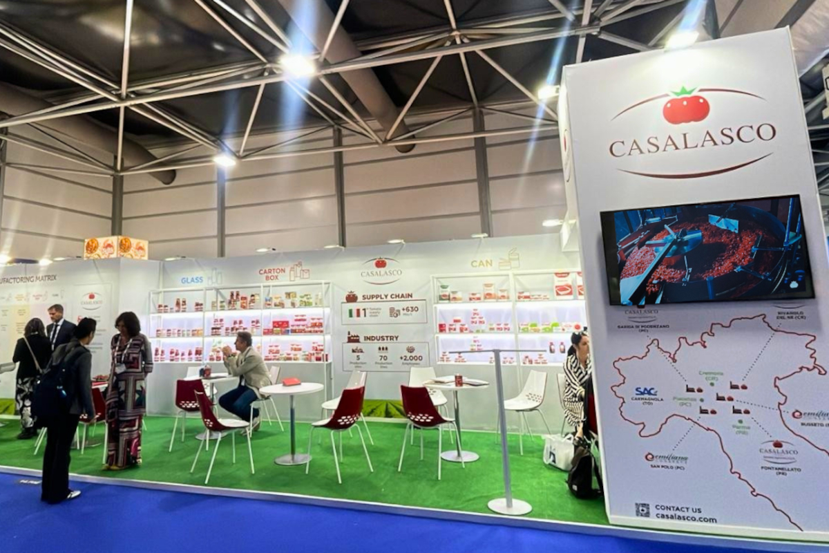 Stand fieristico Casalasco Tuttofood. Espositore di un'azienda alimentare italiana con prodotti a base di pomodoro, mappa e area salotto.