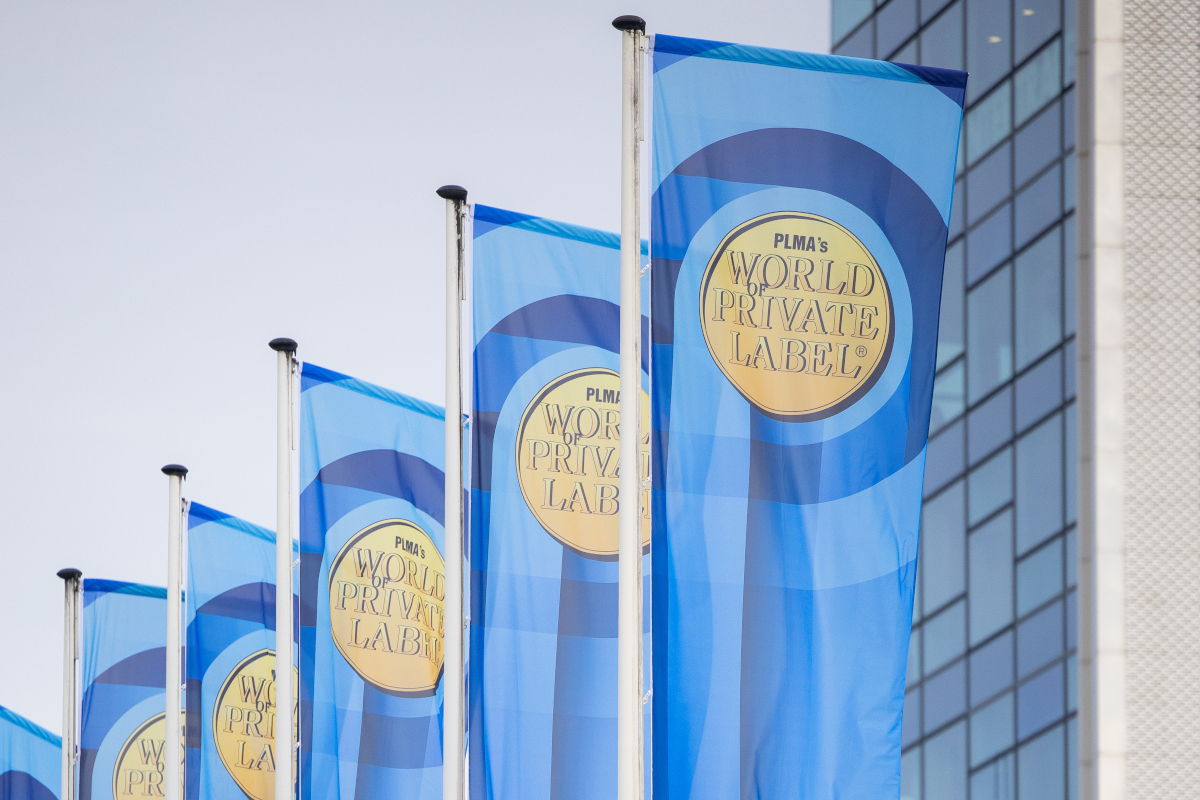 Flags at PLMA's World of Private Label trade show. Blue banners with event logo.
