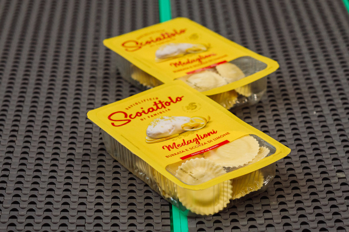 Packaged Scoiattolo Medaglioni pasta. Burrata and lemon ravioli in yellow packaging. Fresh Italian pasta.