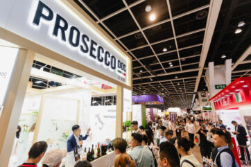 Crowd at Vinexpo Hong Kong wine trade show. Prosecco DOC booth with presenter.