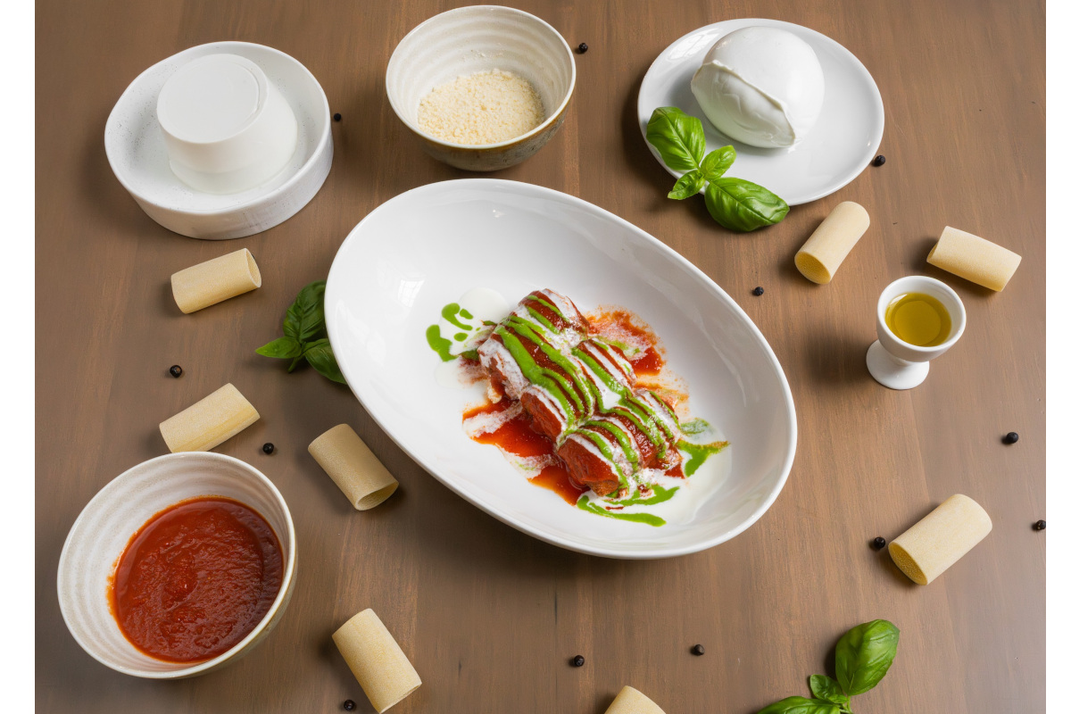 Tuttofood 2026-Tricolore paccheri pasta with mozzarella, tomato sauce, and basil pesto. Italian food.