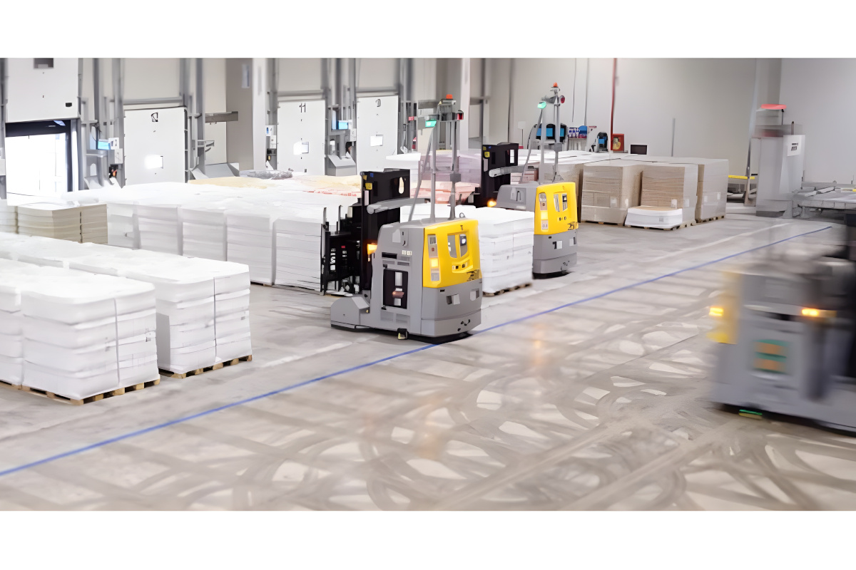 Automated guided vehicles (AGVs) moving palletized goods in a modern warehouse pre-staging area with loading docks.