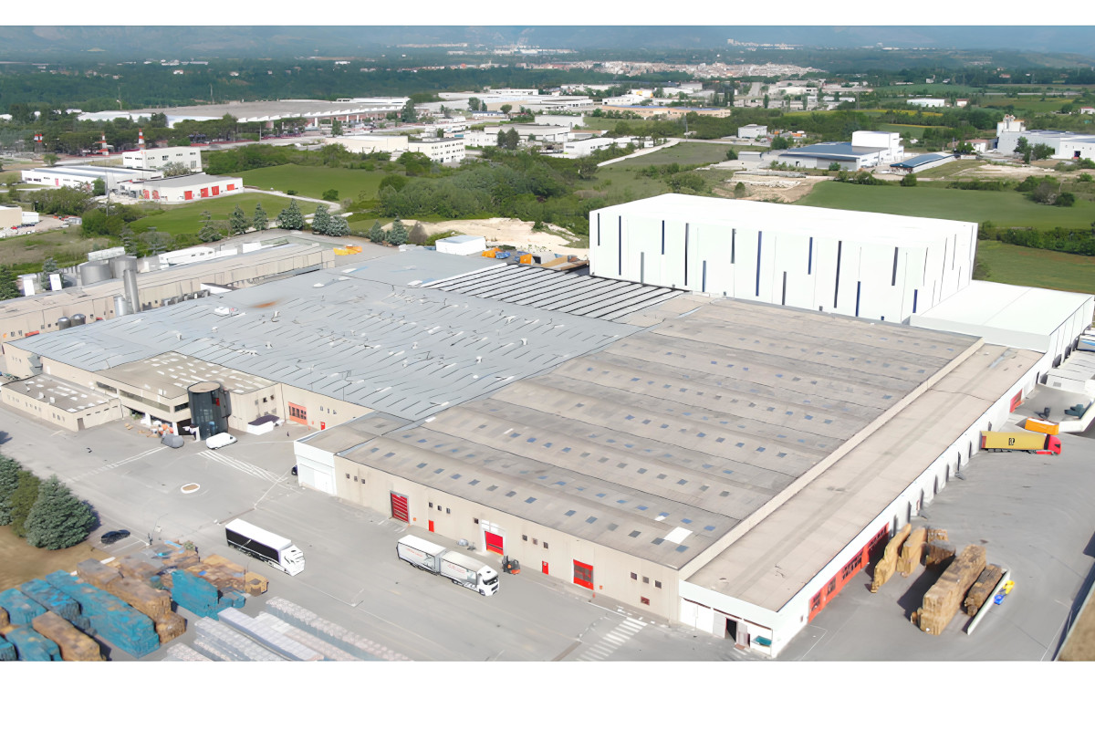 Aerial view of the Refresco Italia manufacturing plant in Sulmona, featuring industrial buildings and freight trucks.