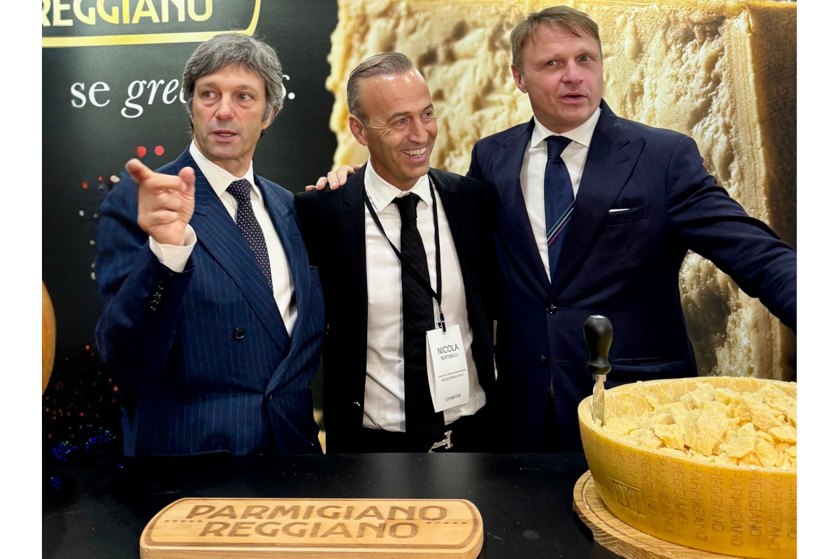 Three men in suits at the Summer Fancy Food Show promoting Parmigiano Reggiano PDO cheese at a branded booth.
