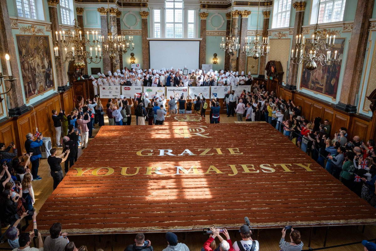 Crowd at Eataly London celebrating a 440.58-metre Guinness World Record tiramisu with Grazie Your Majesty spelled out.
