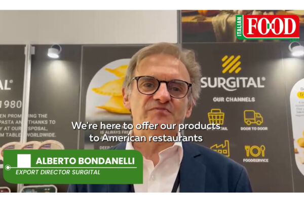 Alberto Bondanelli of Surgital discusses artisanal Italian pasta for US foodservice at a trade show booth.