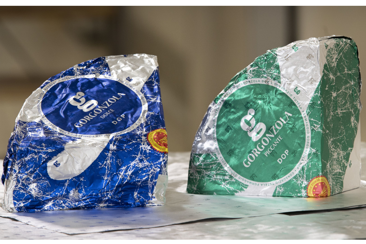 Two wedges of authentic Italian Gorgonzola DOP cheese, one Dolce in blue foil and one Piccante in green foil packaging.