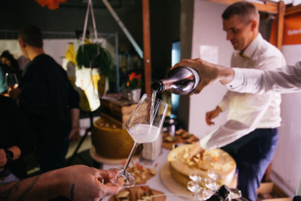 Prosecco DOC poured into a glass at Berlin Frizzante Festival, with Grana Padano PDO cheese on the table