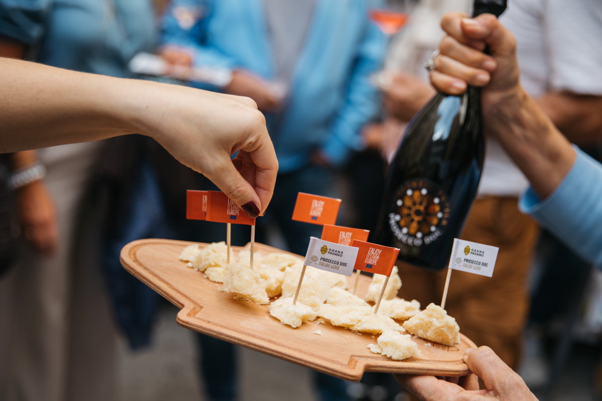 Grana Padano PDO and Prosecco DOC tasting board with flags at joint European campaign event.