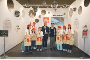 John Armleder and staff at the illy Art Collection booth at Frieze Seoul, featuring disco balls and branded aprons.