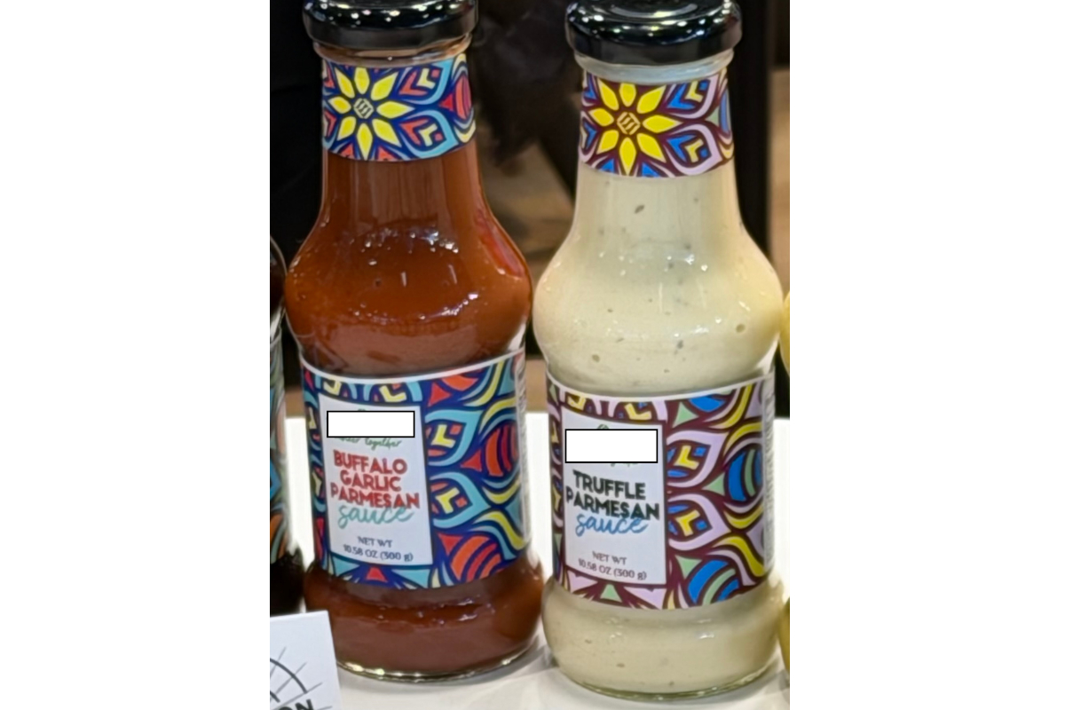 Two bottles of Buffalo Garlic Parmesan and Truffle Parmesan sauces with colorful labels, likely fake Parmesan products at SIAL Paris.