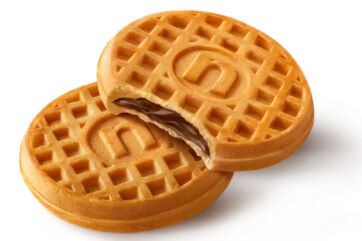 Nutella waffles with chocolate hazelnut filling, one broken open showing creamy spread, on white background.