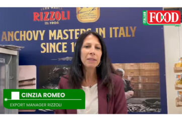 Rizzoli Emanuelli Export Manager Cinzia Romeo interviewed at SIAL 2026 against anchovy masters banner.