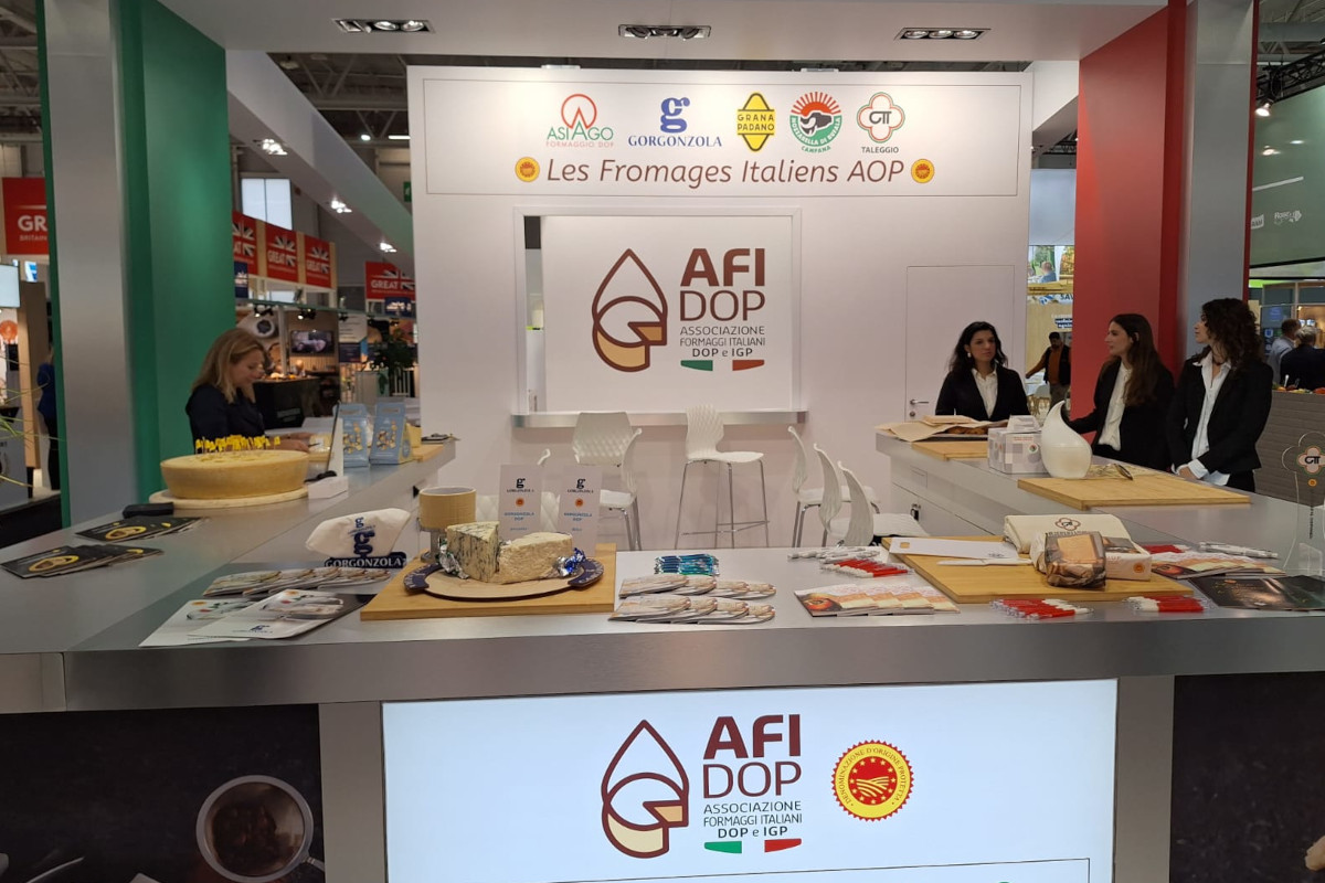 AFIDOP Italia stand at SIAL 2024 showcasing Italian AOP cheeses, with staff, cheese wheels, and promotional displays. - Gorgonzola PDO
