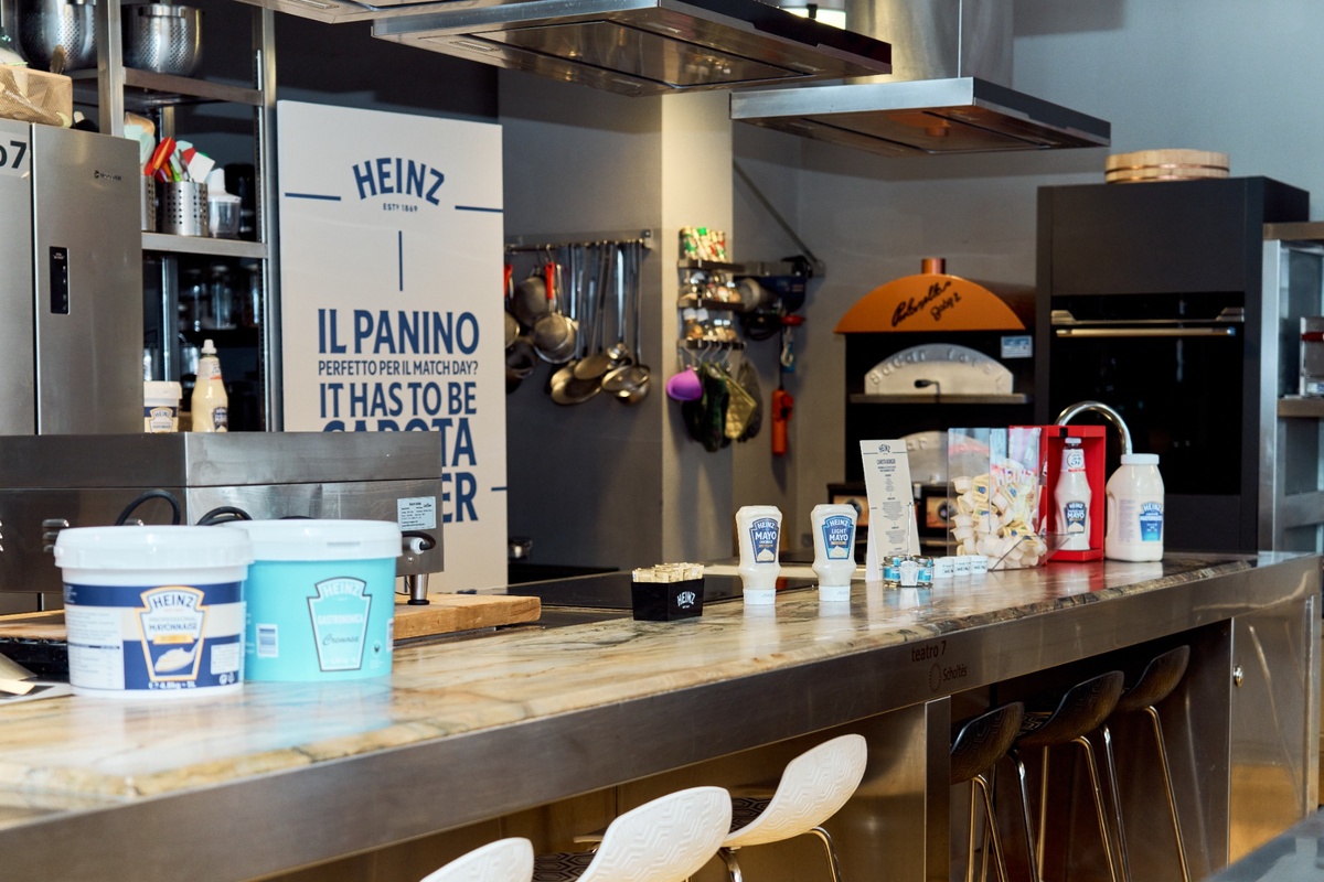 Gamma di maionese Heinz esposta su un bancone da cucina professionale in un ristorante moderno.
