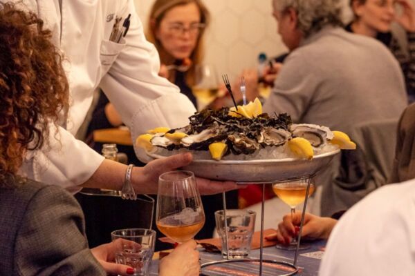 Piatto di ostriche fresche con limone su ghiaccio. Ristorante Tasty Life, cucina di mare.