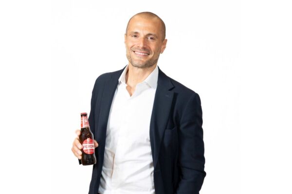 Alessandro Chiodi, nuovo Direttore On Premise Birra Peroni, con una bottiglia di birra Peroni in mano.