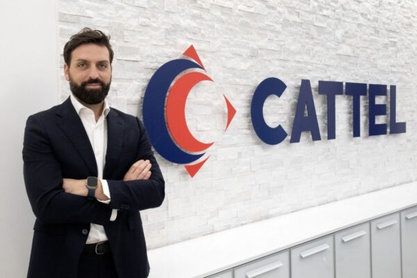 Luca Cittadini, nuovo Responsabile Acquisti di Cattel, ritratto davanti al logo aziendale presso la sede della società specializzata nella distribuzione Horeca.
