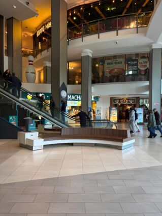 Food court: interno con scale mobili, ristoranti e persone. Power List Top 30 food service.