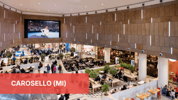 Area food Carosello, Milano. Ristoranti e persone nella food court del centro commerciale.