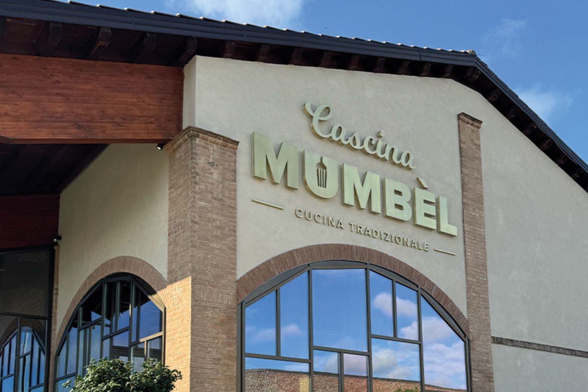 Facciata Cascina Mumbèl, ristorante di cucina tradizionale a Montebello. Architettura con finestre ad arco e insegna dorata.