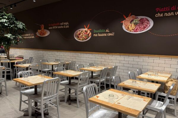 Interni Dispensa Emilia Liguria: tavoli, sedie, decorazioni murali con piatti tipici emiliani. Ristorante accogliente.