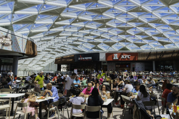 Area ristorazione affollata. Persone ai tavoli, fast food come KFC e Don Peppe.