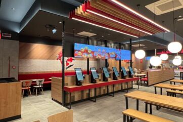 Interno del ristorante KFC a Civitanova Marche. Terminali ordine, tavoli e sedute.