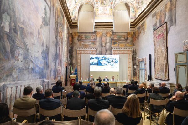 Convegno sulla birra: sala affrescata con pubblico e relatori. Mercato birra in salute.