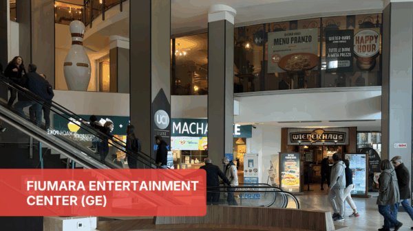 Food Court Fiumara: ristoranti e negozi. Persone sulle scale mobili, insegne di ristoranti.