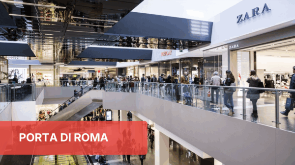 Food court Porta di Roma. Persone che camminano, negozi Zara e Replay.