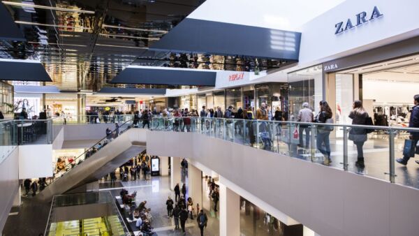 Food court affollata con negozi Zara e Replay.