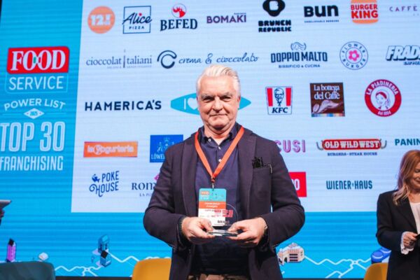 Top 30 Franchising Food Service: uomo con premio. Loghi ristorazione, Burger King, KFC.
