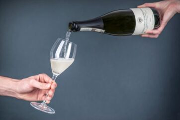 Versando Prosecco Conegliano Valdobbiadene in un calice. Bottiglia di Prosecco. Vino spumante italiano.